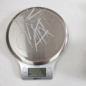 Detailed view of lightweight acrylic icicle ornaments on scale showing 4.2g weight
