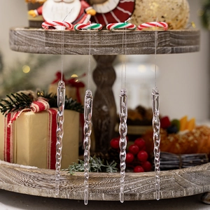 Detailed view of four transparent spiral icicle ornaments hanging on a wooden Christmas shelf