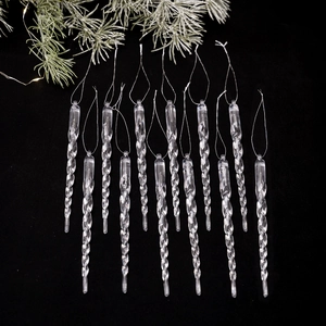 Set of 12 clear acrylic spiral icicle ornaments hanging on a frosted Christmas branch