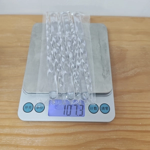 Macro detail of transparent acrylic spiral icicle ornaments weighing 107.3g on a digital scale