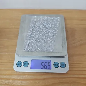 Clear acrylic spiral icicle ornaments being weighed on a digital scale for christmas decor