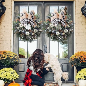 Macro detail of autumn wreath with black white plaid bow and white pumpkins on a door