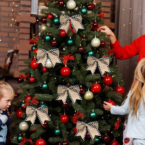 Nœuds de Noël rustiques en toile avec bords à carreaux sur un sapin de fête décoré