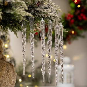 Clear acrylic spiral icicle ornaments hanging on a Christmas tree with festive lights