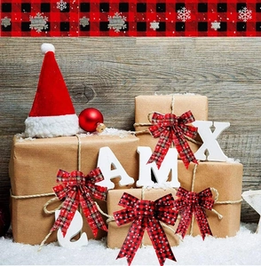 Set of five red and black plaid Christmas bows with white snowflake patterns on snow background