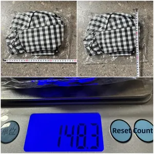 Quality check view of black and white plaid Christmas ribbon showing size and 148g weight
