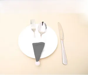 Grey Christmas hat cutlery holder set on a white ceramic plate with silverware