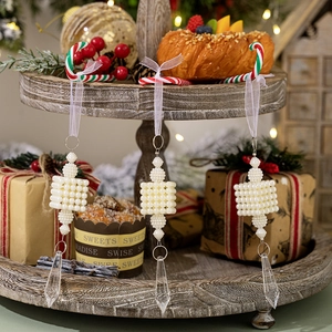 Set of three white pearl icicle ornaments with crystal prisms on festive candy cane hooks