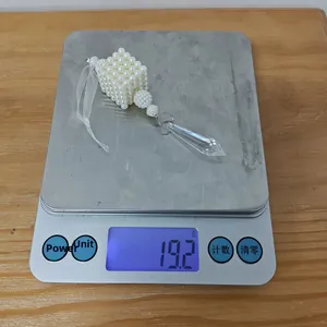 Detail view of pearl ornament with crystal drop showing 19.2g weight on scale