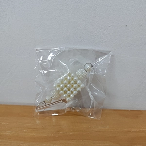 Detail of beaded pearl icicle ornament with white ribbon bow for Christmas decor