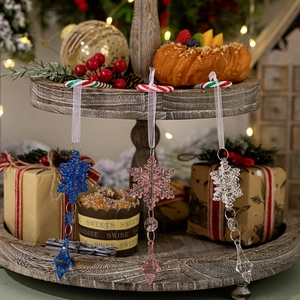 Detailed view of colorful acrylic snowflake pendants hanging in a cozy Christmas setting