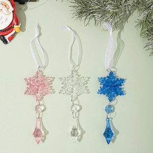 Close-up of snowflake crystal ornaments in pink, blue, and clear colors with ribbons