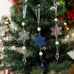 Vista detallada de copos de nieve acrílicos de colores con perlas en árbol de Navidad