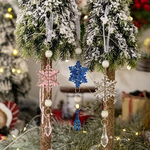 Adornos navideños de copos de nieve en tonos pastel con perlas y cristales en el árbol