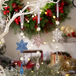 Tres colgantes de copos de nieve acrílicos con cuentas de colores en un árbol de Navidad