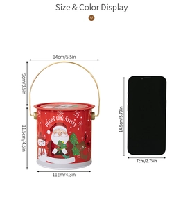 Vue détaillée d'une boîte de Noël en fer blanc rouge avec anse et motifs de fête