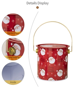 Détail du seau de Noël en métal rouge avec motifs de Père Noël, flocons et anse dorée