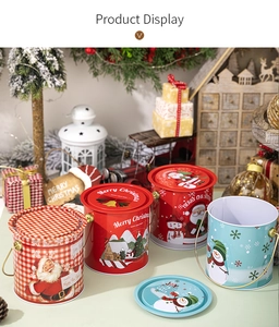 Vue détaillée de quatre boîtes de Noël en fer blanc avec motifs festifs et poignées