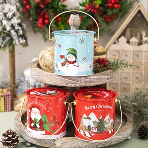 Gros plan de seaux de rangement de Noël festifs rouges et bleus sur plateau en bois
