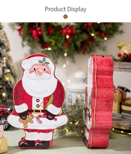 Detail of Santa Claus shaped tin box with festive holiday illustrations and red metal finish
