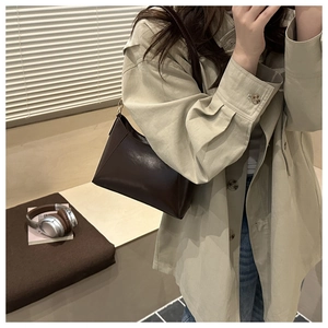 Deep brown leather shoulder bag shown in a mirror selfie with a stylish beige trench coat