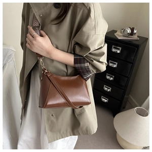 Detail of hobo shoulder bag with vintage jacquard wide strap and brown leather texture