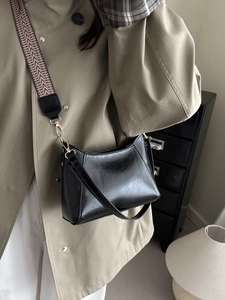 Minimalist black square crossbody bag with glossy finish and stylish fabric shoulder strap