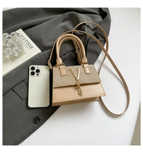 Chic beige crossbody bag with gold glitter flap and V-shaped tassel detail on fabric