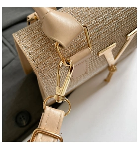 Detailed close-up of a glittering beige mesh handbag featuring a gold V-shaped metal logo