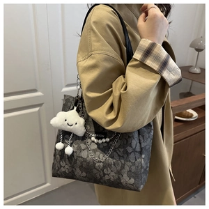 Detail of floral jacquard tote bag with pearl chain and cloud plush charm decoration