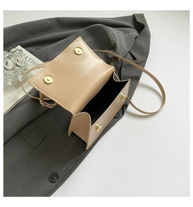 Detail view of khaki crossbody bag with dual gold magnetic clasps and matte leather texture