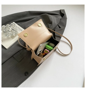 Detail view of the beige crossbody bag interior showing storage space for phone and accessories