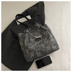 Detail of grey jacquard tote bag with vintage floral pattern, chain and pearl charms