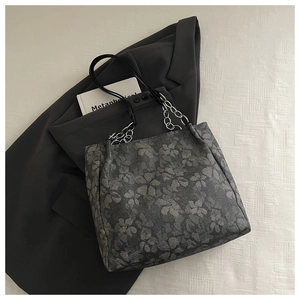 Detailed texture of dark grey floral jacquard tote bag with silver chain strap accents