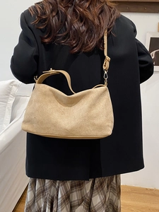 Borsa chic a mezzaluna in camoscio color cammello con tracolla in pelle su modella