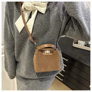 Detail view of brown retro small square bag with leather suede stitching and metal lock