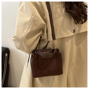 Brown leather crossbody square bag detail with gold metal buckle and suede texture