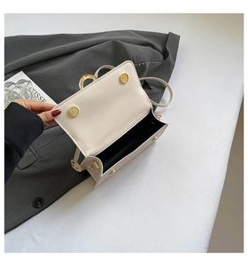 Internal view showing single compartment and magnetic closure of off-white crossbody bag