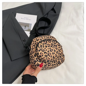 Close-up of leopard print mini crossbody bag featuring dual zippered pockets and nylon strap
