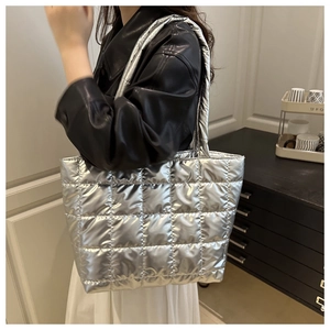 Sac fourre-tout matelassé argenté porté par un mannequin dans un style décontracté chic