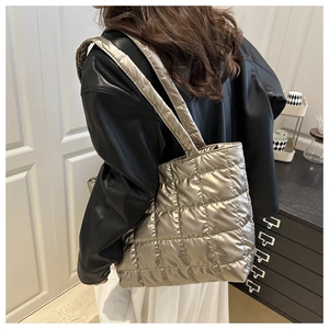 Détail du sac cabas matelassé doré champagne montrant la texture brillante et la bandoulière