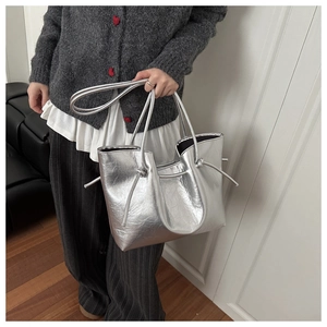 Dettaglio borsa tote argento metallizzato con coulisse a nodo laterale e manici