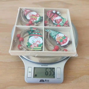 Gros plan de quatre pendentifs de gnomes de Noël en bois dans une boîte de rangement