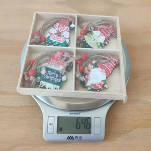Vue détaillée de quatre ornements de Noël en bois dans une boîte pesant 64,6 grammes
