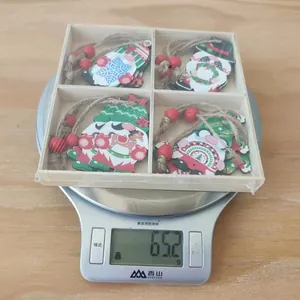 Lot de pendentifs nains de Noël en bois dans une boîte pesé sur une balance