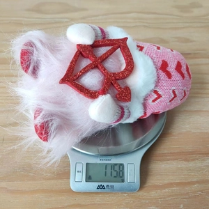 Close-up of Valentine gnome plush toy on an electronic scale weighing 115.8 grams