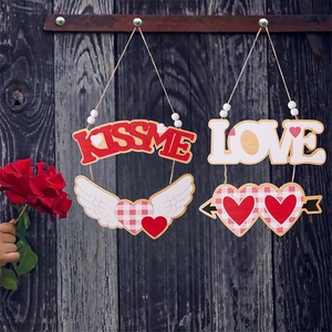 Détail de suspensions en bois de Saint-Valentin avec KISS ME et LOVE sur fond sombre