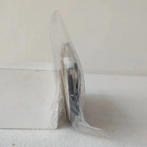 Vue latérale du pendentif cœur de Cupidon en bois dans son emballage en plastique