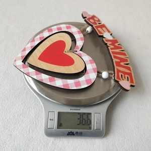 Dettaglio di un ciondolo a cuore in legno con motivo a quadri dal peso di 36,6g