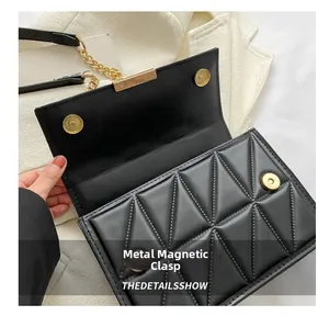 Detail of the golden metal magnetic snaps and quilted texture on a black crossbody bag